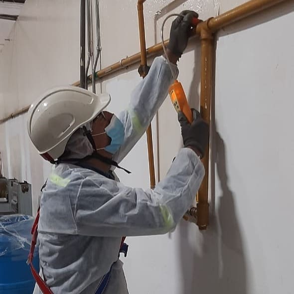 Operario llevando consigo un detector de gas portátil compacto para brindar protección personal durante tareas específicas